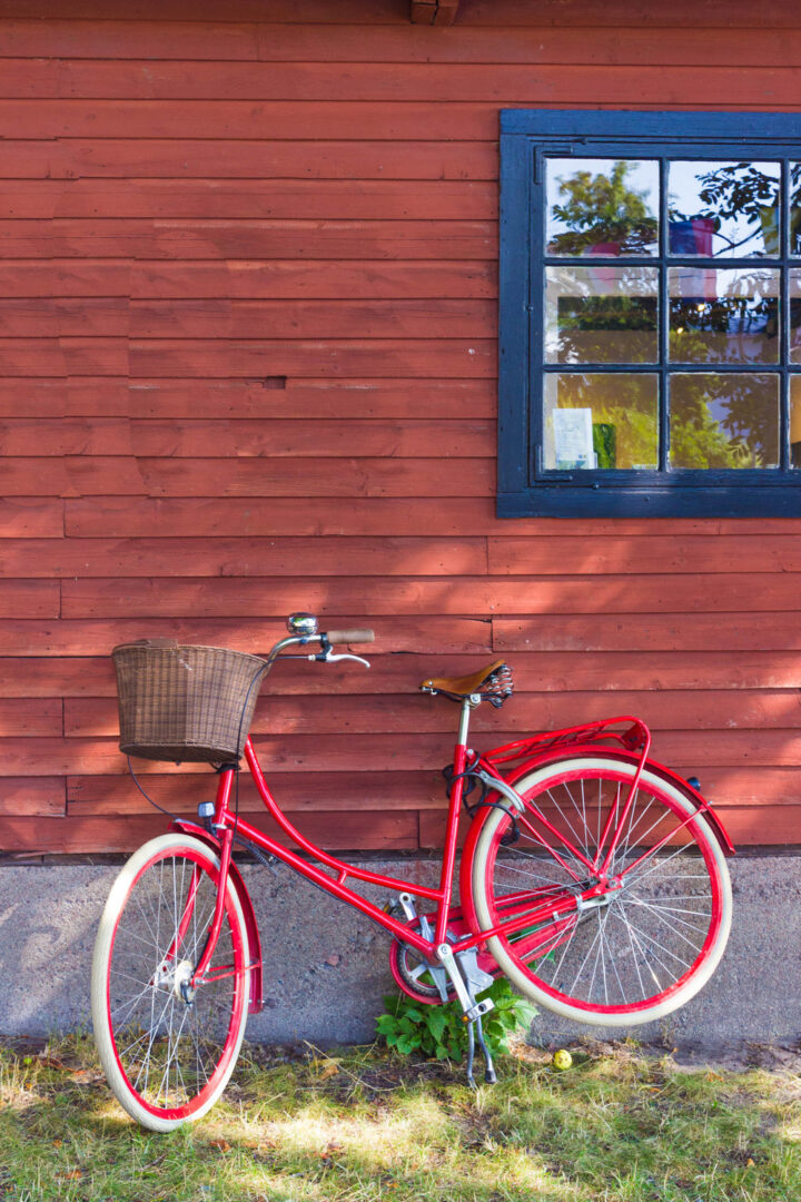 A bike rests against a traditional red house on one of the islands in Sweden's archipelago 
